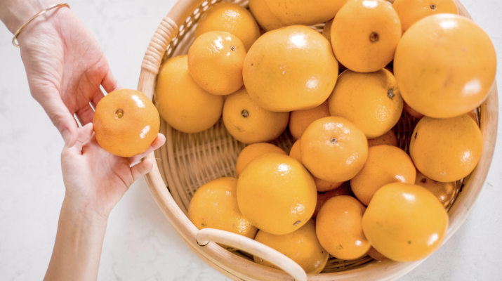 picking out an orange from a basket