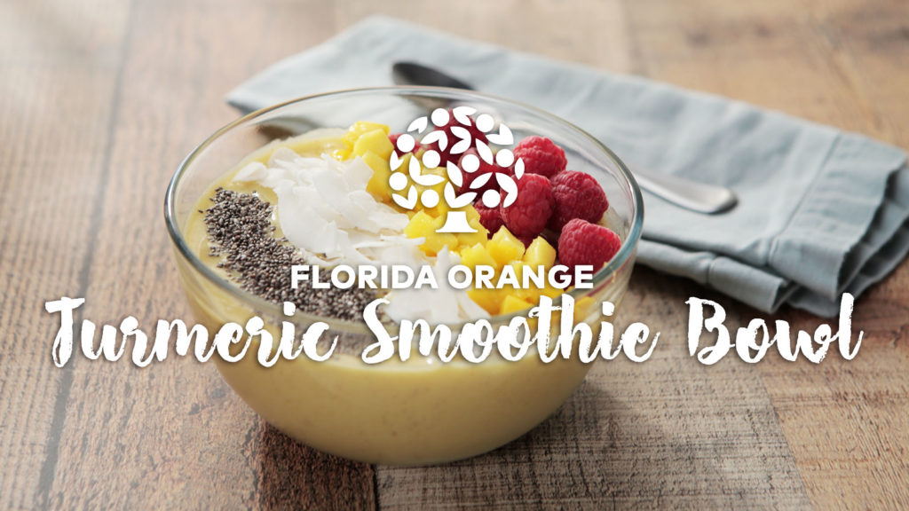 florida orange juice smoothie bowl topped with mango, berries, coconut and chia seeds