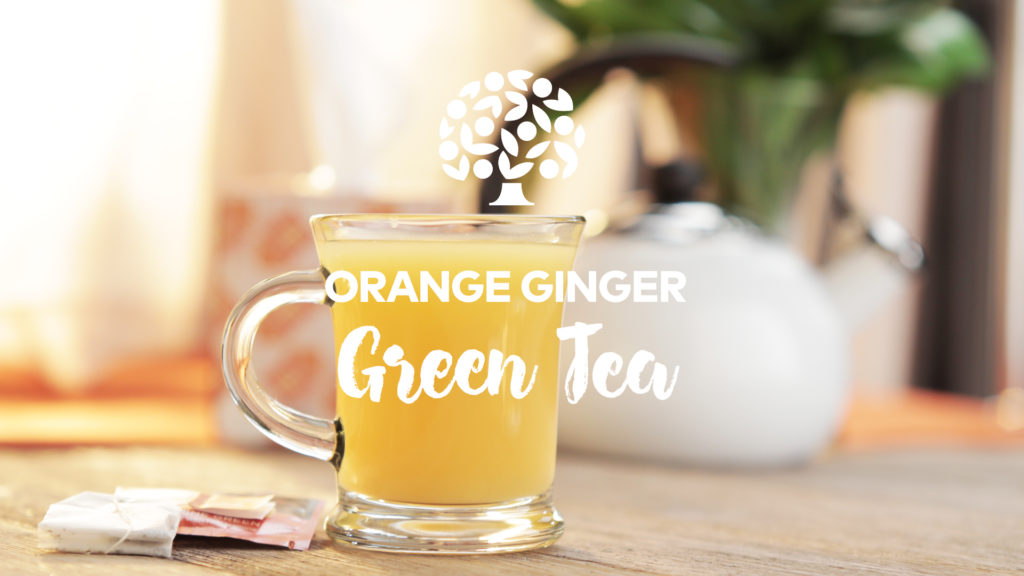 orange ginger green tea in a clear glass mug on a table