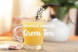 orange ginger green tea in a clear glass mug on a table