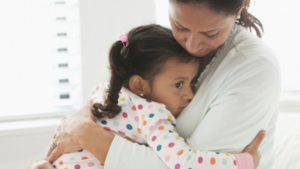 parent comforting a sick daughter