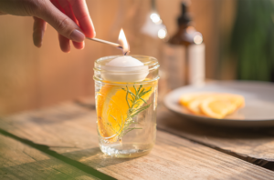 floating candle in a glass above an orange slice