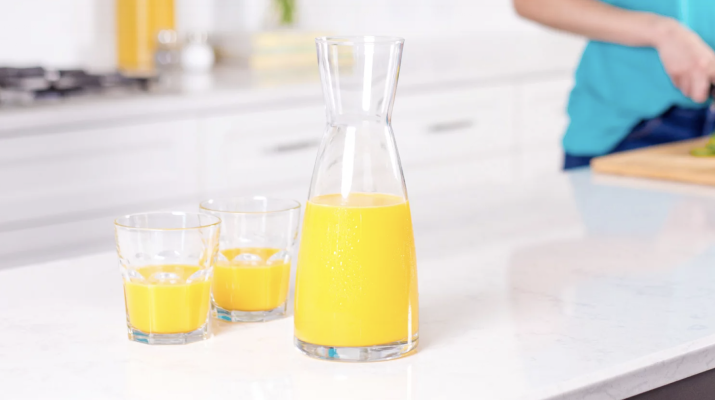 carafe of orange juice next to two glasses